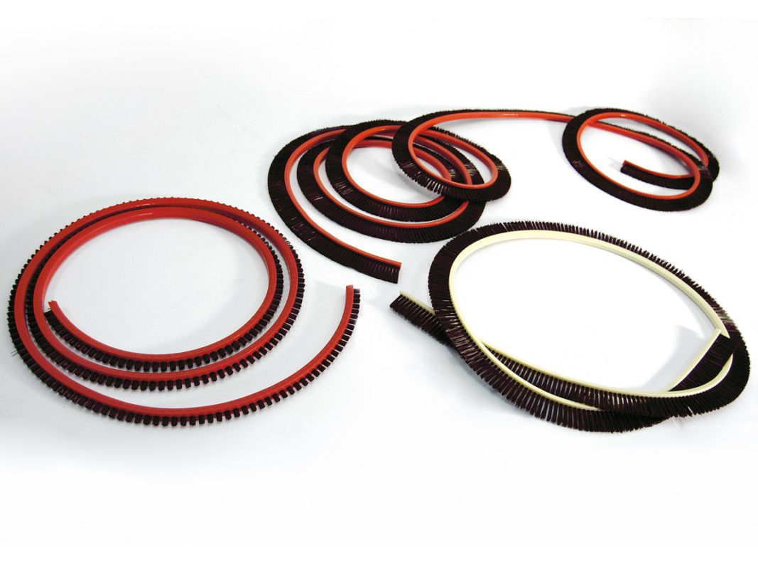 Trapezoidal section flexible belt brush for conveyor belts.